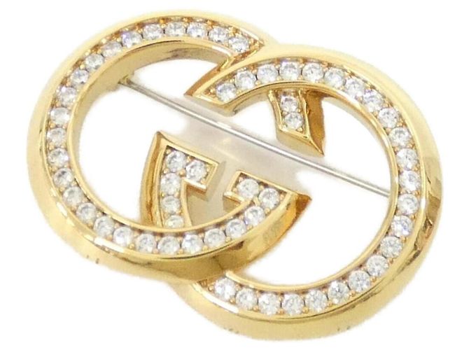Broche transparente et dorée Gucci