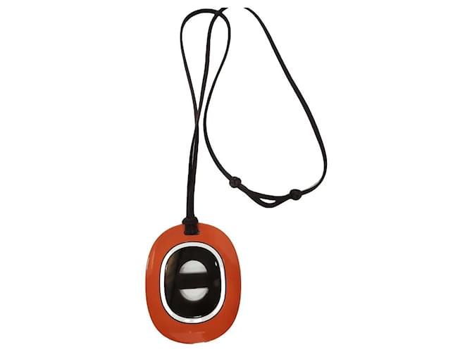 Collier pendentif Hermès en résine orange et noir 