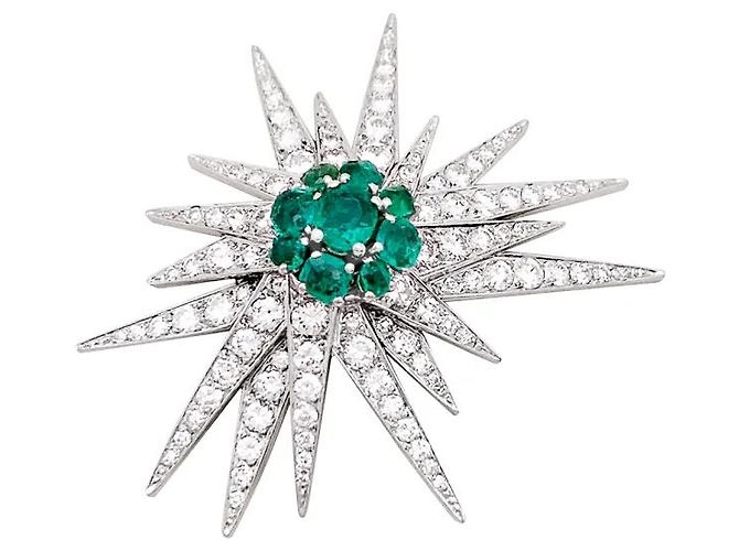 Autre Marque Spilla "Étoile", oro bianco, platino, smeraldi e diamanti.