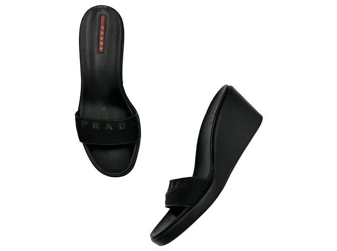 Elegant Prada wedge mules crafted from smooth black leather