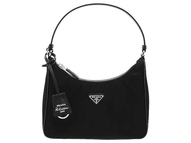 Uma mala hobo icónica que reinterpreta modernamente o arquivo da Prada. Fabricada em material Re-Nylon, é leve e resistente a manchas, e finalizada com acabamentos em couro Saffiano para uma durabilidade excecional. Preto