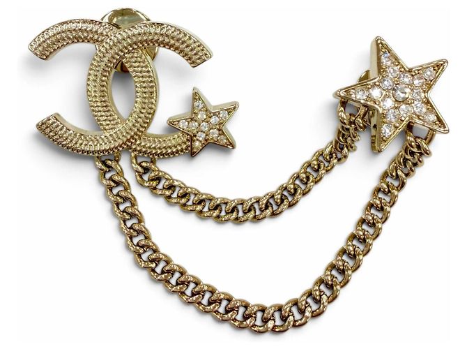 Broche Chanel em metal dourado Coco Mark Star com corrente e strass