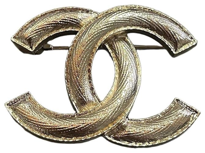 Broche Chanel forma CC en metal dorado