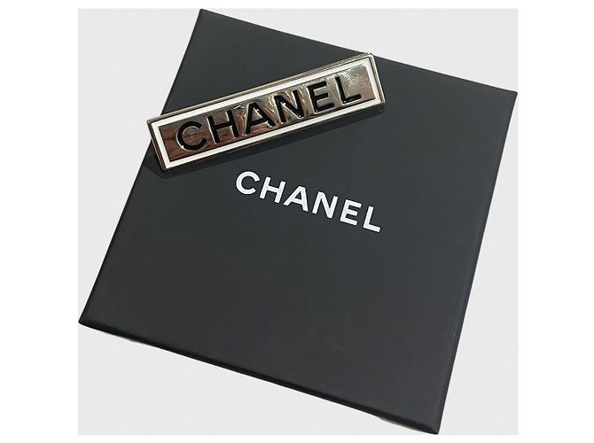 Broche rectangular Chanel en metal dorado con grabado negro