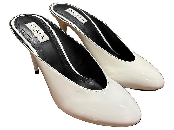 Mules Alaïa em couro patente branco de bico fino