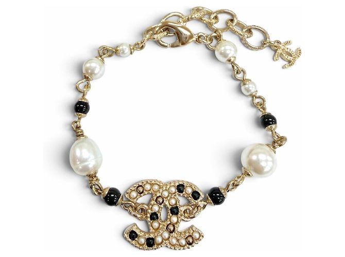 Pulseira Chanel com pingente de pérola eco e logo Coco em metal dourado