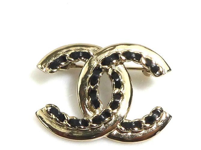 Broche de couro preto e dourado Chanel