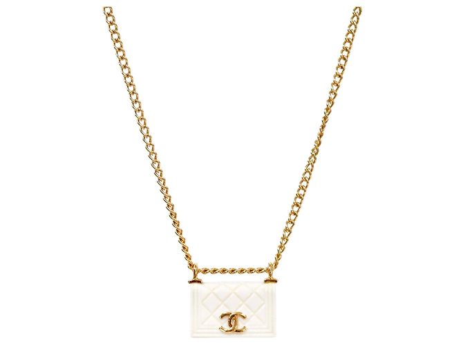Chanel Bolsa acolchoada branca
Colar dourado