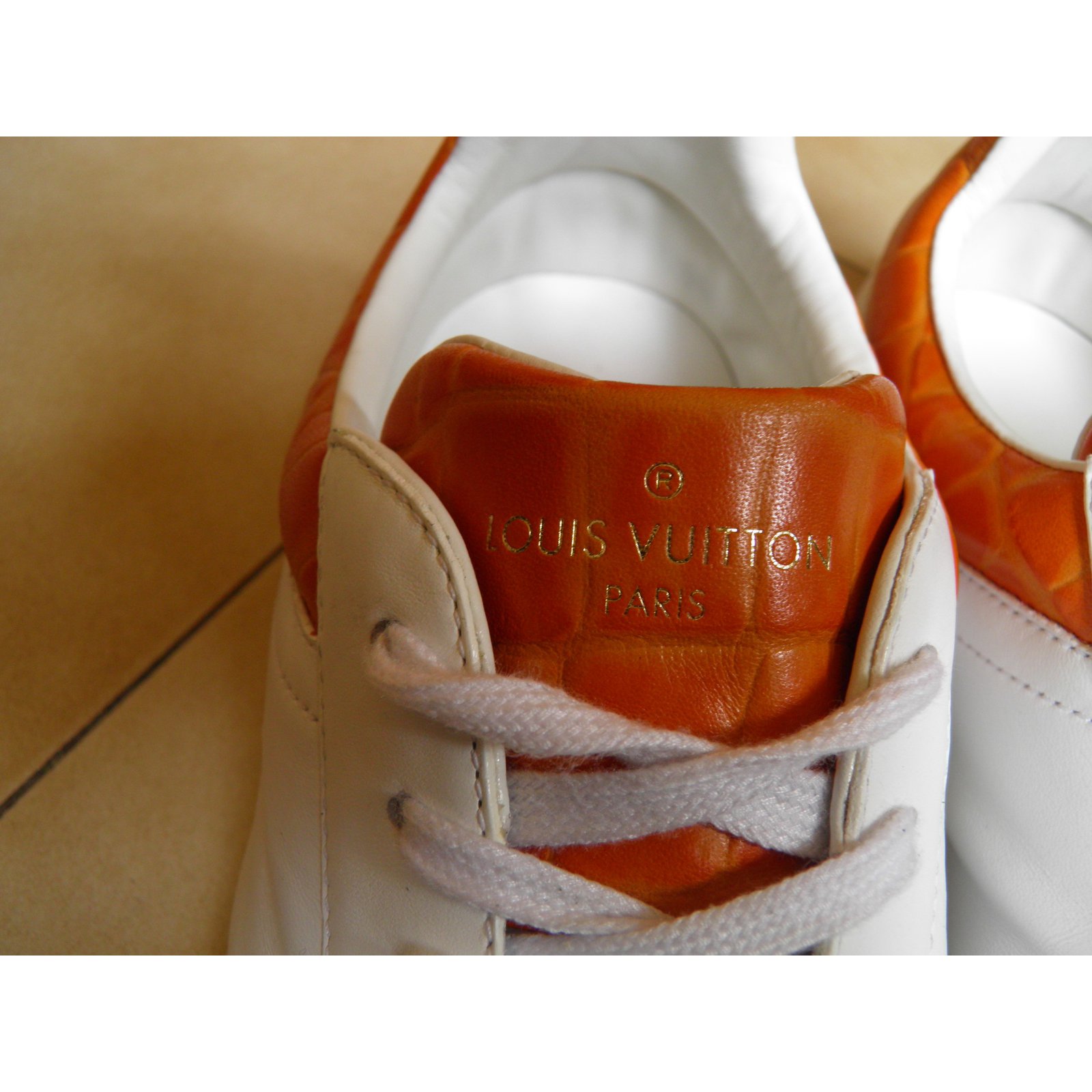 LOUIS VUITTON, a pair of white leather and red suede sneakers. - Bukowskis