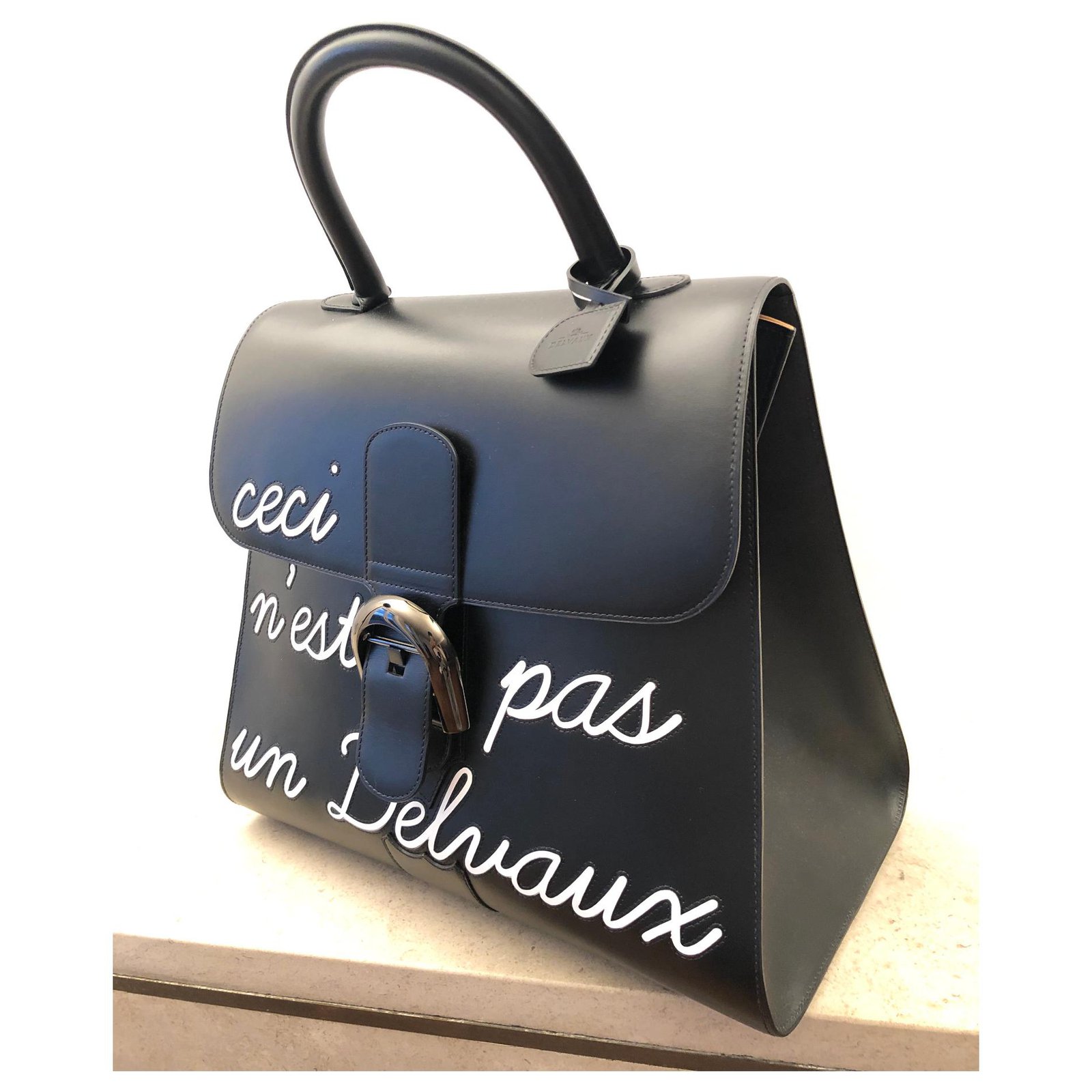 A woman in black with a handbag in sorbetto. 🖤💛💙 #rougecloset Outfit: @Delvaux  Brillant mini box calf in sorbetto #delvaux…