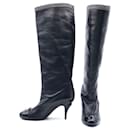 Chanel boots in black leather with patent toes & bow & silver chain trim