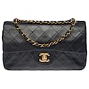 The coveted Chanel Timeless bag 23 cm with lined flap in black quilted lambskin, garniture en métal doré