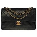 The coveted Chanel Timeless bag 23 cm with lined flap in black leather, garniture en métal doré
