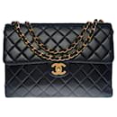 Majestic Chanel Timeless Jumbo bag in black quilted caviar leather, garniture en métal doré