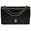 The coveted Chanel Timeless/Classic medium bag 25 cm with lined flap in black leather, garniture en métal doré