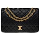 Sublime Chanel Timeless/Classic handbag 27 cm in black quilted leather, garniture en métal doré
