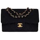 The coveted Chanel Timeless bag 23 cm with lined flap in black linen, garniture en métal doré