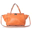 Valentino Garavani, Tote Rockstud Trapeze en naranja.