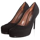 Tabitha Simmons, Sapatos pretos de bico redondo com babados e plataformas ocultas e salto coberto.
