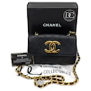 Bolso bandolera pequeño con solapa y charm Coco grande en dorado de Chanel.