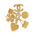 Broche con dijes de icono de Chanel dorado