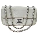 Petit sac à rabat avec symboles précieux en cuir embossé blanc Chanel