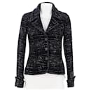 Veste en tweed noir avec boutons en CC à 9 000 $. - Chanel
