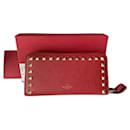 Magnífica y muy elegante cartera Rockstud Valentino Garavani con cremallera en cuero de becerro granulado rojo.