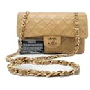 Bolso Chanel Timeless mediano de 23 cm con doble solapa en cuero de cordero acolchado beige.