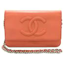 Portafoglio arancione Chanel CC Caviar su borsa a tracolla con catena