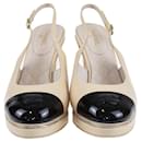 Zapatos de tacón con tira trasera y logo CC entrelazados en negro/beige de Chanel