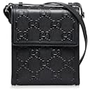 Sac messager perforé en relief Gucci GG noir