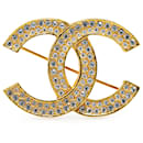 Broche Chanel en or plaqué or avec strass et marque Coco