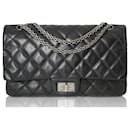 Bolso de doble solapa acolchado negro Chanel Reissue 2.55