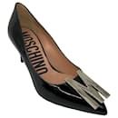 Pompes en cuir verni Moschino noires / argent plaque M