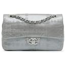 Bolso de hombro de doble solapa en piel de ternera brillante plateada, adornado con remaches Chanel mediano.