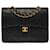 A cobiçada bolsa média Chanel Timeless/Classic 25 cm com aba forrada em couro preto acolchoado, garniture en métal doré Pele de cordeiro  ref.545866