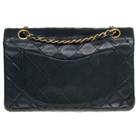 Chanel-Die begehrte Chanel Timeless Tasche 23cm in dunkelblauem gestepptem Leder mit goldener Metallverkleidung-Marineblau