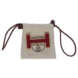Hermès FIVELA DE CINTO HERMES QUIZZ EM METAL DOURADO COM FUNDO DE IMITAÇÃO DE LAGARTO VERMELHO Dourado