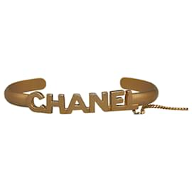 Chanel-Brazalete con logo dorado de Chanel y anillo de cristal CC con cadena adjunta-Dorado