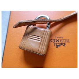 Hermès-Hermès leather-wrapped padlock, bell, and zipper pull in gold Barénia calf leather.-Camel
