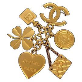 Spilla CC Chanel dorata con charm D'oro