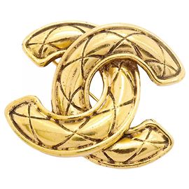 Broche Chanel con el logo Coco Dorado