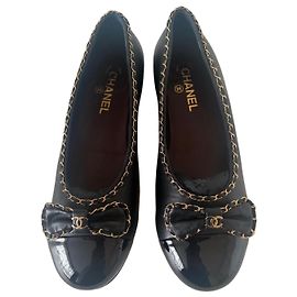 Sapatilhas Chanel em couro preto com bico fechado e detalhe de corrente dourada Preto