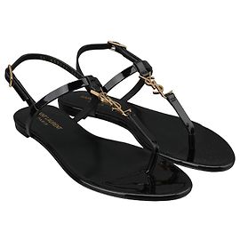 Saint Laurent Sandales plates Cassandra en cuir verni Noir
