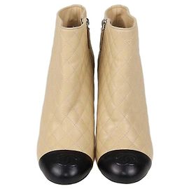 Botas de cano curto Chanel em couro acolchoado Beige/Black com bico CC Cap Toe Preto Bege