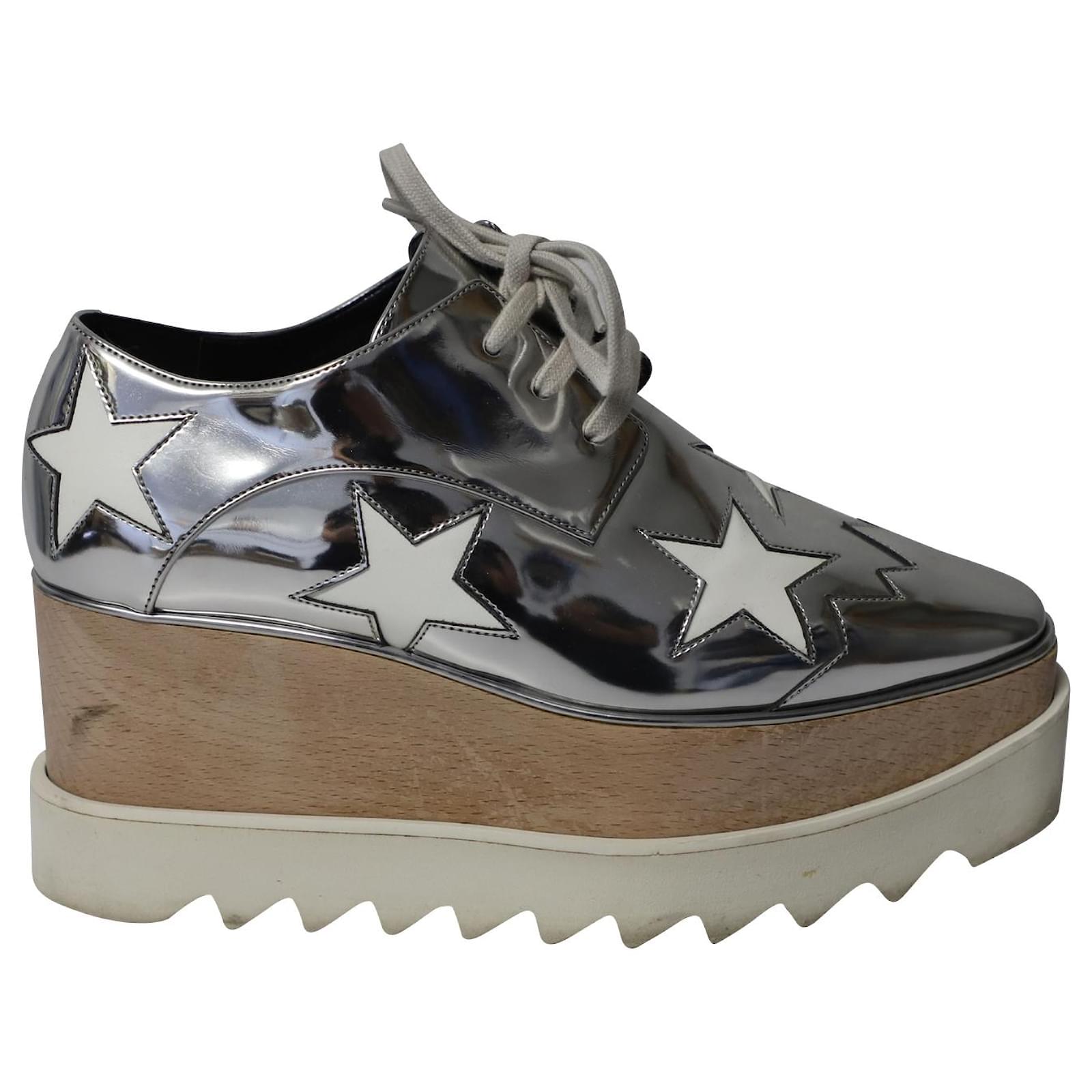 https://cdn1.jolicloset.com/imgr/full/2022/10/655837-1/stella-mccartney-elyse-star-platform-lace-up-sneakers-in-silver-faux-patent-leather-tops.jpg